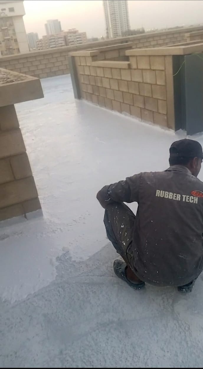 Rubber Tech Plus technician applying waterproofing membrane on a concrete terrace