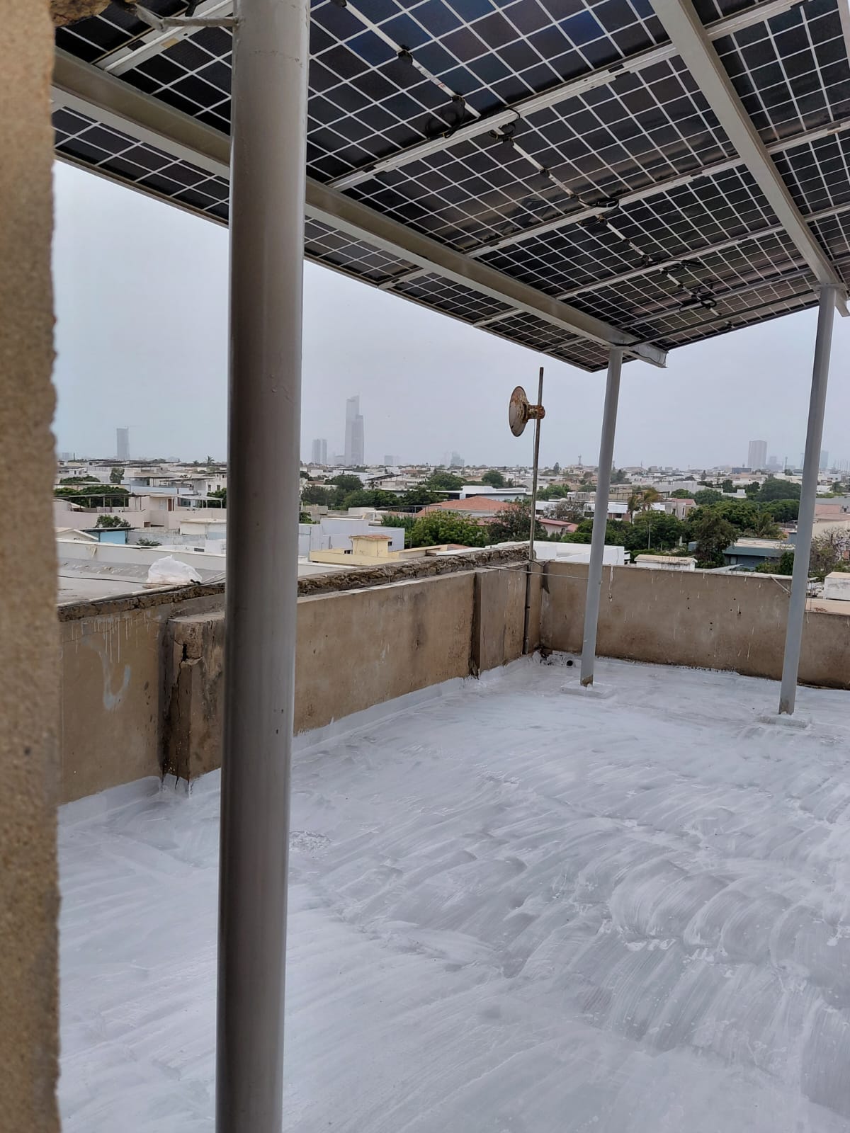 Completed liquid membrane waterproofing beneath a rooftop solar structure