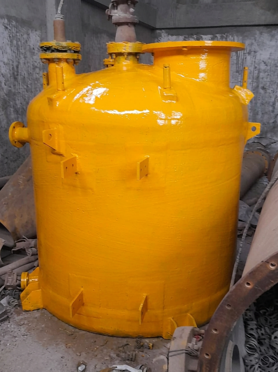 Restored vertical industrial vessel with a clean yellow protective finish
